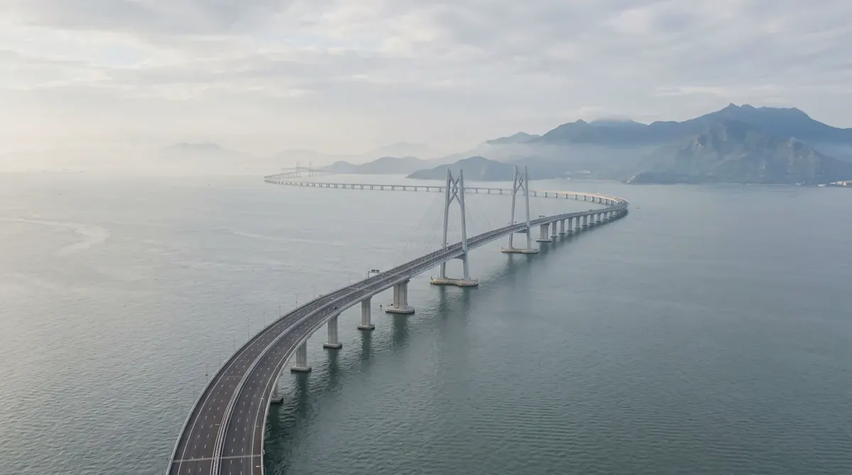 A long sea bridge curving across the Pearl River Delta between Hong Kong and Macau in hazy morning light